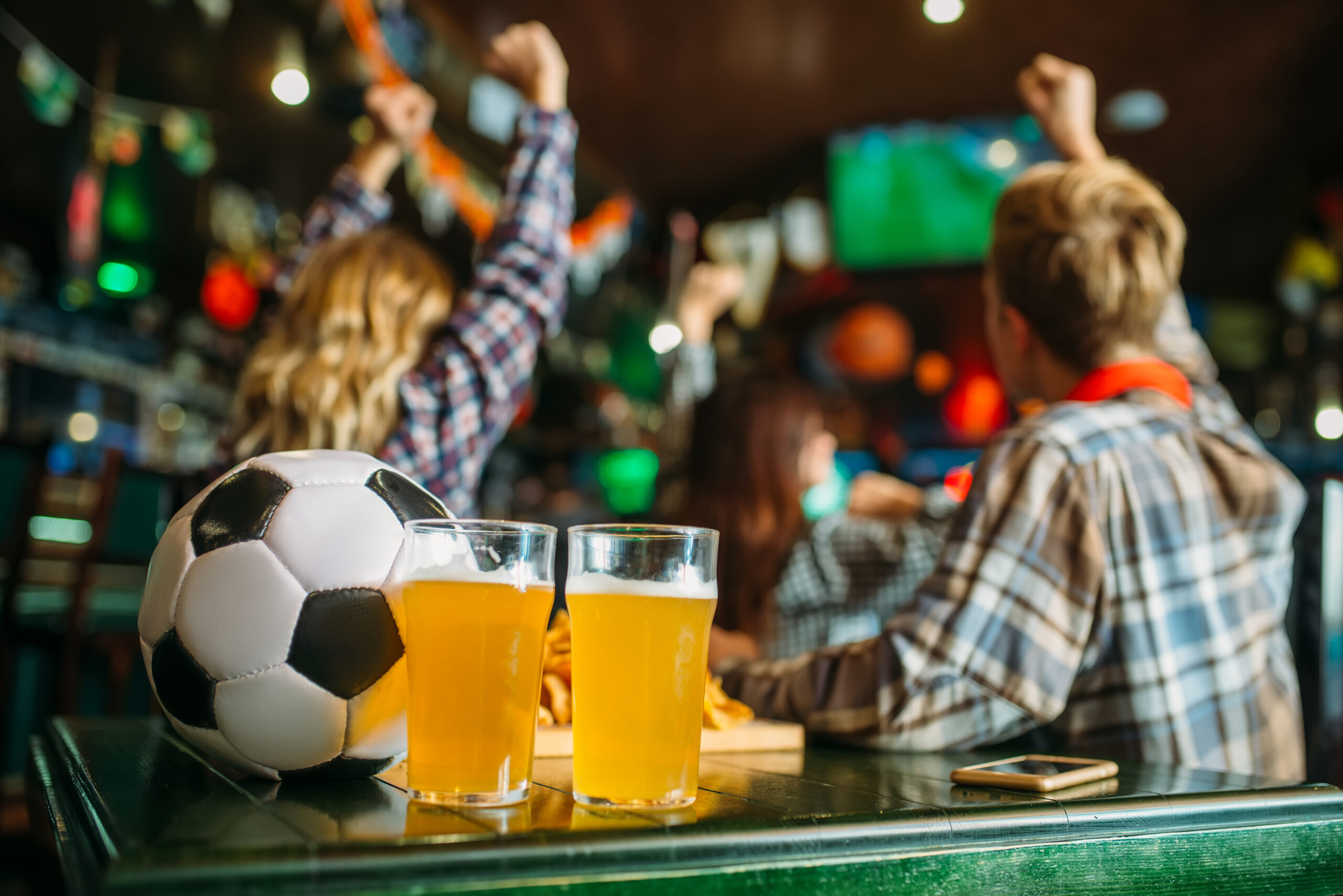 Ball and beer in sports bar, game watching concept